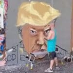 WATCH: Popular Atlanta Muralist Paints Giant Mural of Trump’s Mugshot