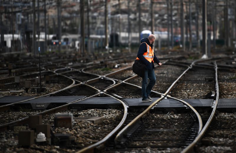 TOPSHOT - A man crosses the railroad tracks at the gare Saint-Charles in Marseille on April 9, 2018 as French rail workers launched their latest two-day strike over plans to overhaul the national state-owned railway company SNCF. . / AFP PHOTO / ANNE-CHRISTINE POUJOULAT (Photo credit should read ANNE-CHRISTINE POUJOULAT/AFP via Getty Images)