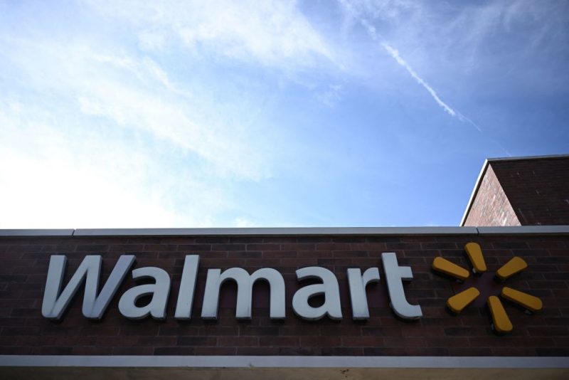 A sign for Walmart is displayed outside its store in Washington, DC, on November 2, 2022. - CVS Health said they had agreed to pay approximately $5 billion over 10 years to "resolve all opioid lawsuits and claims" against them by states and cities. Walgreens and Walmart have also agreed to settlements of at least $4 billion and $3 billion, according to a report by Bloomberg. (Photo by Brendan SMIALOWSKI / AFP) (Photo by BRENDAN SMIALOWSKI/AFP via Getty Images)