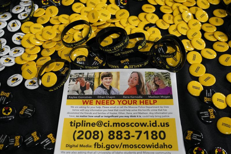 ILE - A flyer seeking information about the killings of four University of Idaho students who were found dead is displayed on a table along with buttons and bracelets, on Nov. 30, 2022, during a vigil in memory of the victims in Moscow, Idaho. It's been nearly three weeks since four University of Idaho students were found stabbed to death in a home near campus, but there are still more questions than answers surrounding the investigation. (AP Photo/Ted S. Warren, File)