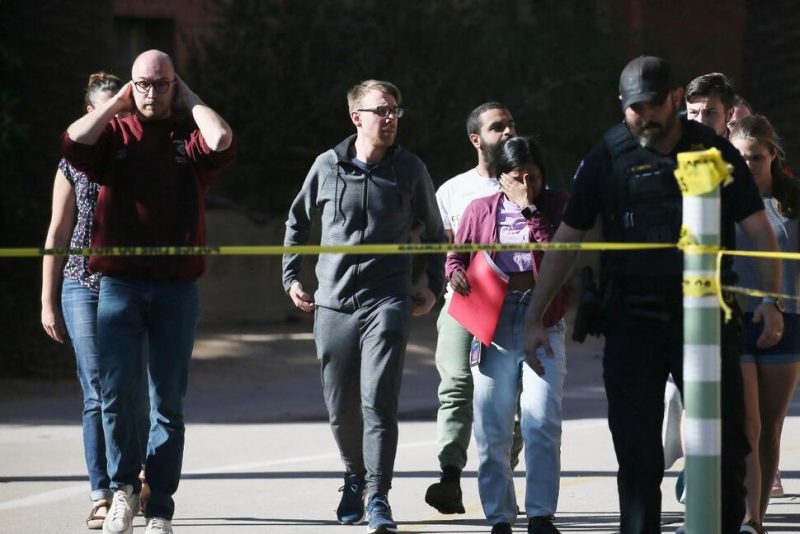 University of Arizona Police escort students from the scene of a shooting at the John W. Harshbarger Building on the University of Arizona campus in Tucson, Ariz., on Wednesday, Oct. 5, 2022. University of Arizona police say one person was shot and wounded on campus and authorities are searching for the suspect. (Rebecca Sasnett/Arizona Daily Star via AP) THE ASSOCIATED PRESS