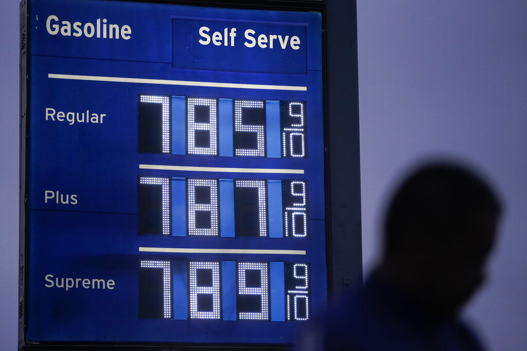 FILE - High gas prices are shown as a pedestrian waits to cross the street in Los Angeles, June 16, 2022. President Joe Biden on June 22 will call on Congress to suspend the federal gasoline and diesel taxes for three months. It's a move meant to ease financial pressures at the pump that also reveals the political toxicity of high gas prices in an election year.(AP Photo/Jae C. Hong, File)