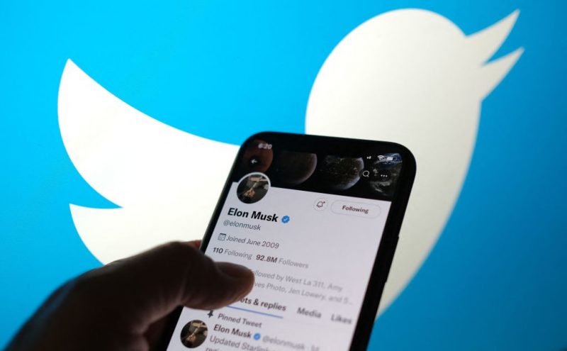 This illustration photo taken May 13, 2022, displays Elon Musks Twitter account with a Twitter logo in the background in Los Angeles. - Elon Musk sent mixed messages Friday about his proposed Twitter acquisition, pressuring shares of the microblogging platform amid skepticism on whether the deal will close. In an early morning tweet, Musk said the $44 billion takeover was